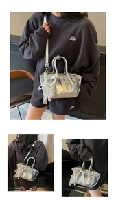 Silver mini bucket bag with pearl lace bow detail shown in various carrying styles