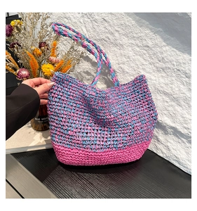 Détail du sac cabas tissé main rose et bleu avec une texture en maille ajourée élégante