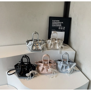 Collection of pleated bucket bags in multiple colors with pearl bow charms on display