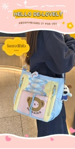 Détail d'un sac bandoulière en toile contrastée avec imprimé ours et breloques peluche