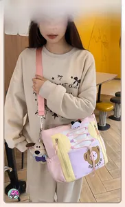 Détail du sac cabas en toile à motif dessin animé bicolore avec bandoulière et pendentif