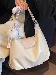 Grand sac cabas beige avec lanières roses porté par un mannequin en tenue décontractée