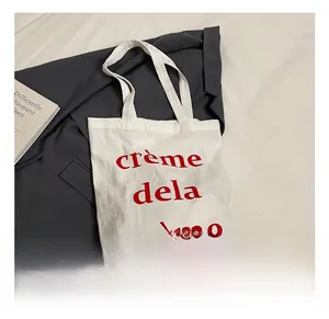 Détail du sac cabas en toile blanche avec imprimé rouge crème de la crème sur tissu