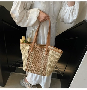Detail of hollow woven straw tote bag with brown leather straps and tulip decor
