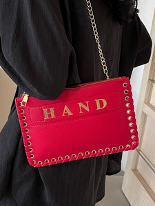 Red pebbled leather woven chain bag with gold HAND hardware on black dress