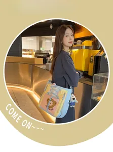 Détail du sac cabas en toile avec imprimé ours et pendentif en peluche petit chien