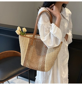 Detail of hollow contrast color straw tote bag with brown synthetic leather handles