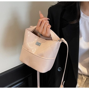 Dettaglio della borsa a secchiello rosa trapuntata con trama in pelle e placca in metallo