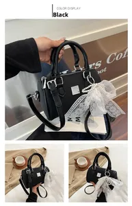 Detail of black Boston handbag with textured PU leather, silver hardware and pearl bow charm