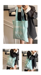 Détail du sac cabas en toile vert menthe avec lettrage blanc et bandoulière pratique