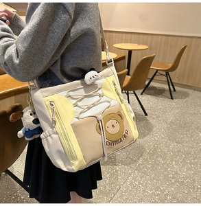 Détail du sac de dessin animé avec poche en filet, cordon et pendentifs en peluche