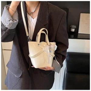 Détail du sac seau blanc crème avec texture en cuir ciré et breloques en dentelle perlée