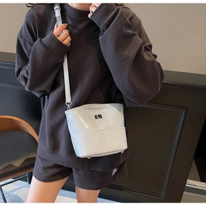 Borsa a secchiello in pelle verniciata trapuntata bianca con chiusura argento indossata