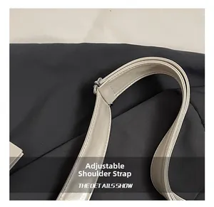 Détail de la bandoulière réglable sur le sac fourre-tout crème en similicuir souple