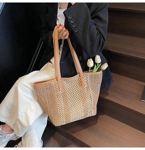 Detail of hollow woven straw tote bag with brown leather straps and tulip decor