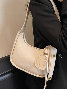 Chic beige lychee pattern underarm bag with cute dog pendant and golden hardware details