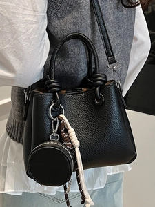 Fashionable black litchi pattern leather bucket bag with woven charm and strap for women