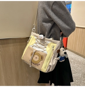 Détail d'un sac cabas dessin animé multicolore avec imprimé ours et pendentif peluche