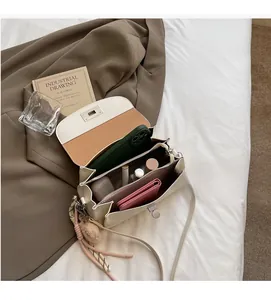 Top down view of cream pillow bag interior with multiple compartments and silver turn lock