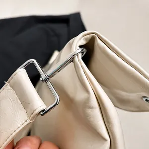 Détail du crochet en métal argenté et texture du cuir beige du sac cabas minimaliste