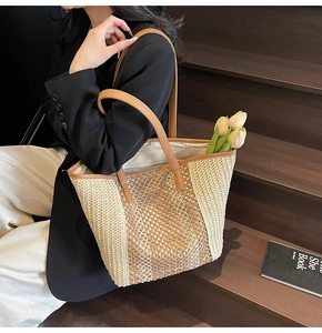 Detailed macro view of woven straw texture and premium brown leather handle on tote bag