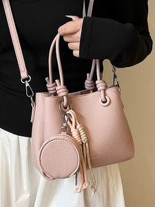 Pink litchi texture bucket bag with woven tassel and round coin purse accessory