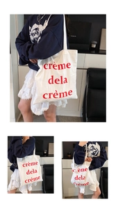 Détail du sac cabas en toile blanche avec inscription rouge et texture en coton épais