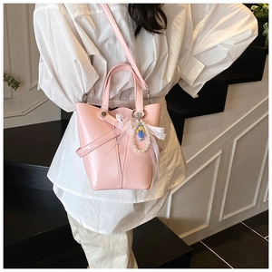 Sac seau en cuir ciré rose avec nœud en dentelle et pendentif poupée en perles élégant