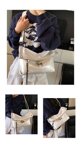 Détail du grand sac cabas argenté métallisé avec ornement papillon porté par un modèle