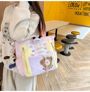 Détail du sac fourre-tout coloré avec des breloques en peluche et des poches zippées latérales