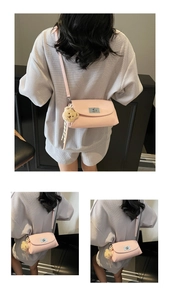 Detail of pink leather crossbody bag with silver twist lock and cute plush bear charm