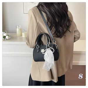 Chic black Boston bag with pearl lace charm shown in a sophisticated lifestyle setting