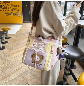 Détail du sac de dessin animé rose et jaune avec breloques panda et chien peluche