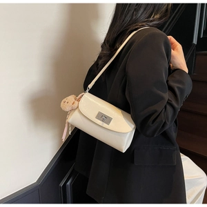 Creamy PU leather pillow bag featuring a silver twist lock and a cute plush bear charm