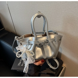 Silver pleated bucket bag featuring pearl lace bow detail and metallic finish handles