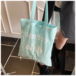 Détail du sac cabas en toile vert menthe avec inscription blanche creme de la creme