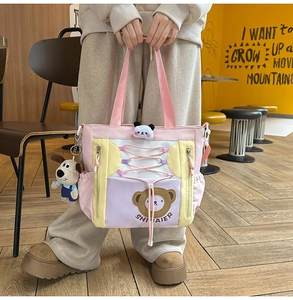 Détail du sac cabas en toile bicolore avec imprimé ours et pendentifs en peluche
