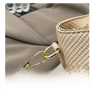 Detail of premium gold metal hook and beige woven texture on luxury bucket bag