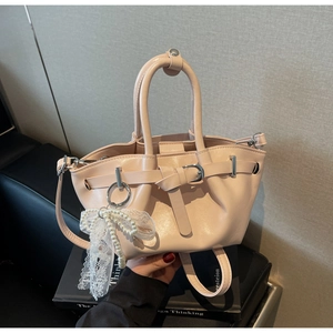 Detail of light pink PU bucket bag with lace pearl bow charm and silver hardware