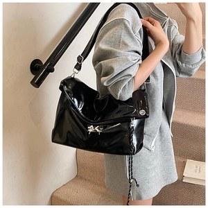 Vue détaillée du sac cabas en cuir verni noir brillant avec détails argentés et breloques