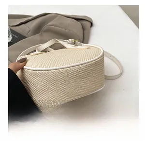 Detail showing the wear-resistant round bottom and woven texture of the cream bucket bag