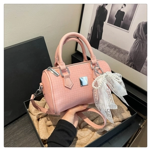 Detailed texture of pink tweed boston bag with elegant lace pearl bow and silver hardware