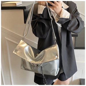 Gros plan d'un sac cabas en cuir souple argenté métallisé avec ornement papillon chic