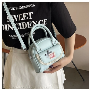 Detail of light blue PU leather bag with lace trim and cute rabbit patch on side