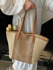 Minimalist straw tote bag with brown leather handles and decorative tulips