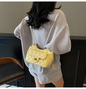 Bright yellow quilted chain bag shown on a model's shoulder for size and style reference