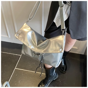 Détail du sac argenté métallisé avec boucle papillon et cordon de serrage tressé
