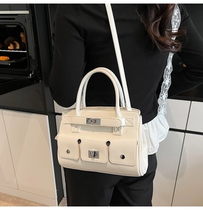 Detail of cream multi-pocket tote bag with silver turn-lock hardware and leather texture