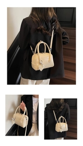 Detail of cream Boston bag with pearl grape charm and detachable leather strap
