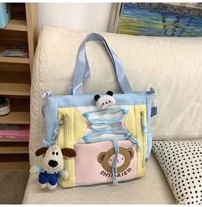 Détail d'un sac fourre-tout en toile avec décor panda et porte-clés chien en peluche